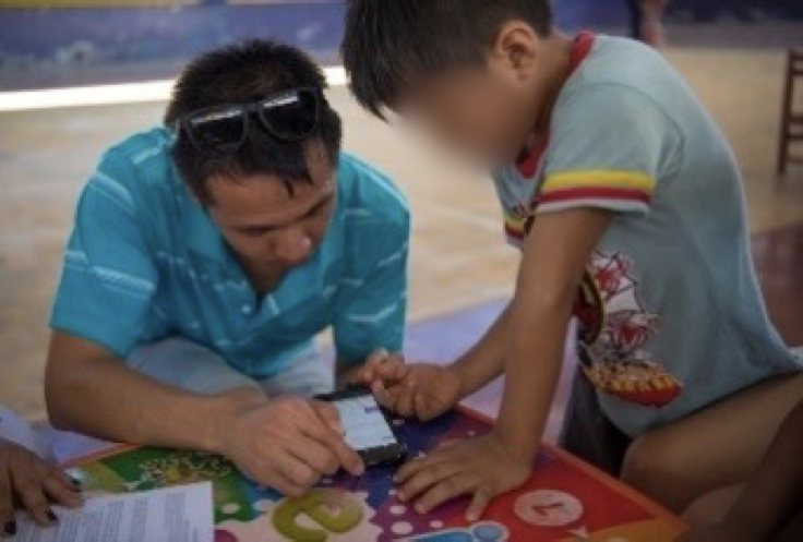 Professor Wang testing a smartphone health app with a child during a field deployment.